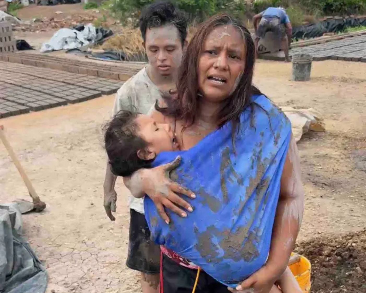 Cecilia holding her child at the brick yard